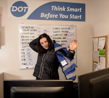 Brandi in the office putting on vest